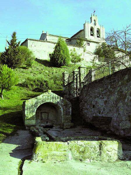 Iglesia de San Pedro, arriba, con la fuente románica en primer plano.